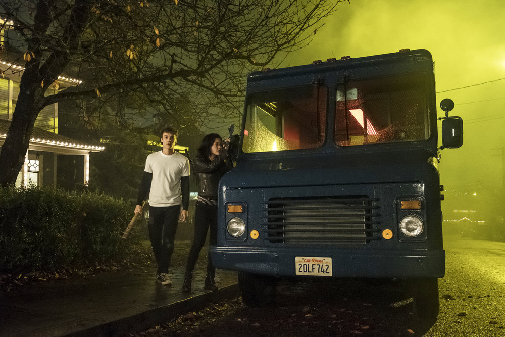 Saya scopes out the place behind the group's large blue truck.