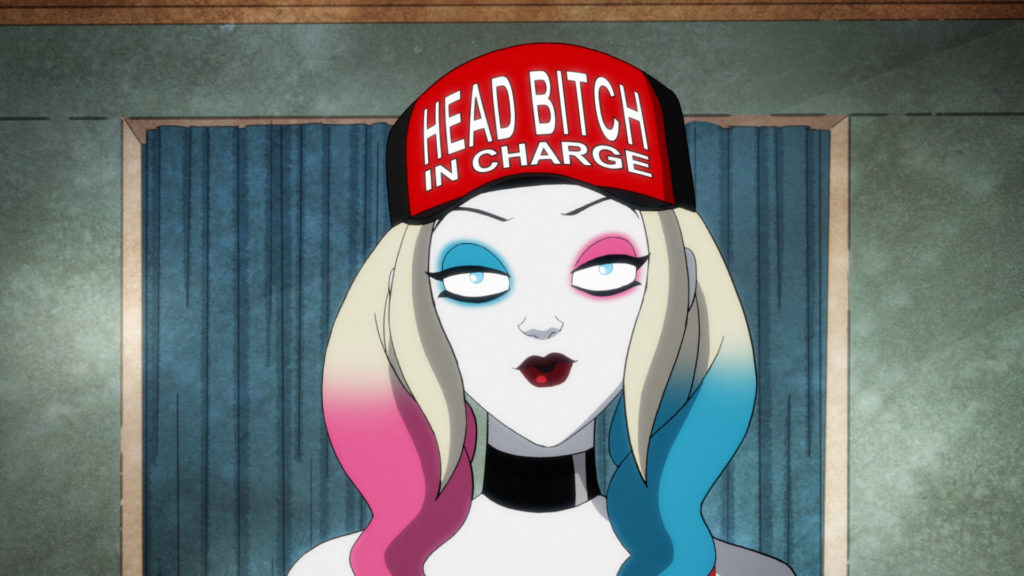 Harley Quinn wearing a red hat that says Head Bitch in Charge.