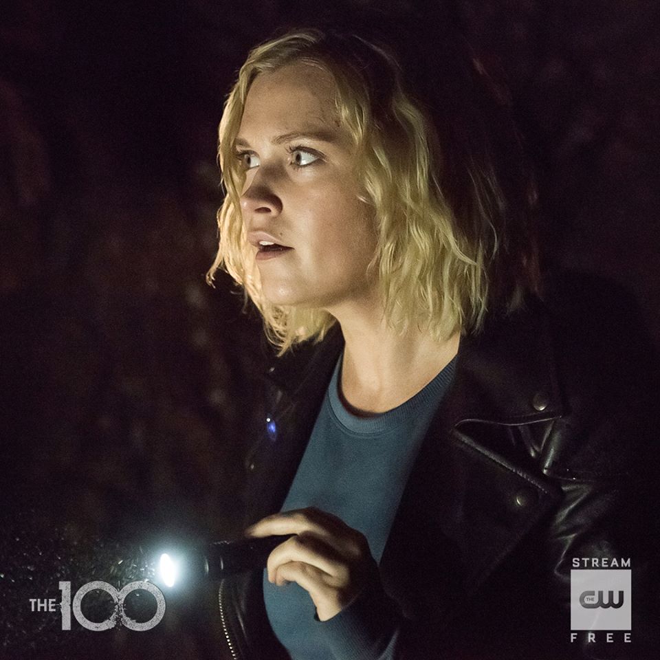 Clarke Griffin in a cave with a flashlight.