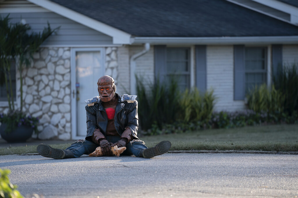 Brendan Fraser/Riley Shanahan as Cliff Steele sitting on the road.