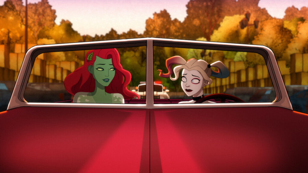 Left to Right (In a red car no top): Poison Ivy and Harley Quinn