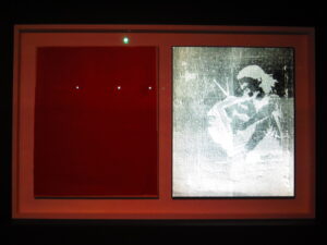 Brad Downer’s Hyperspectral photograph of Banksy’s TV Girl on the right, with original image being painted over in red on the left