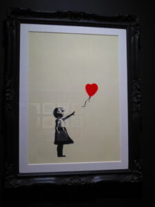 Girl with Balloon by Banksy. Silkscreen print of a girl letting go a heart balloon
