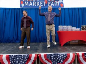 two of the cast talk during market fair