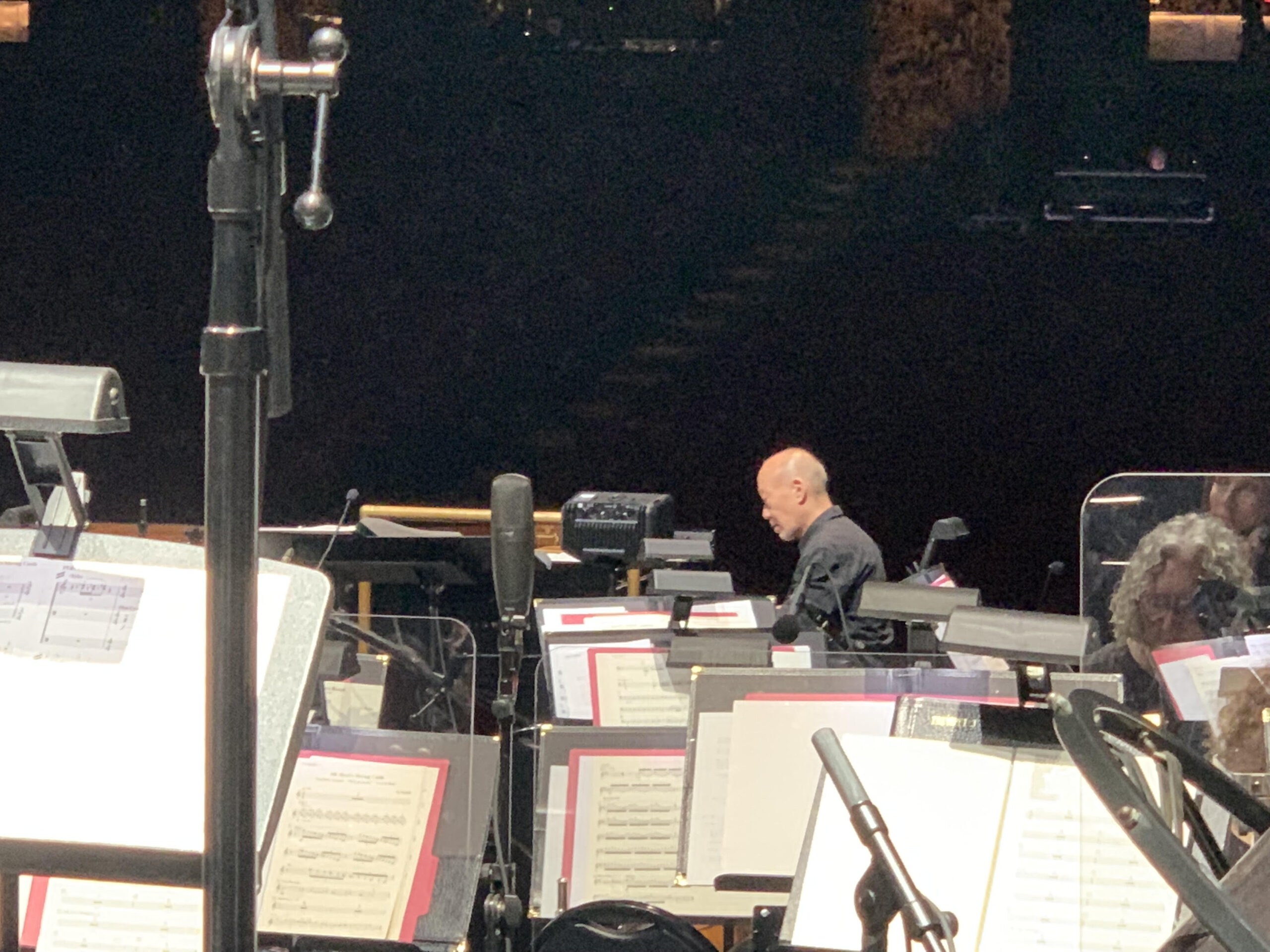 Joe Hisaishi, a 71 year old Japanese man, plays piano on stage