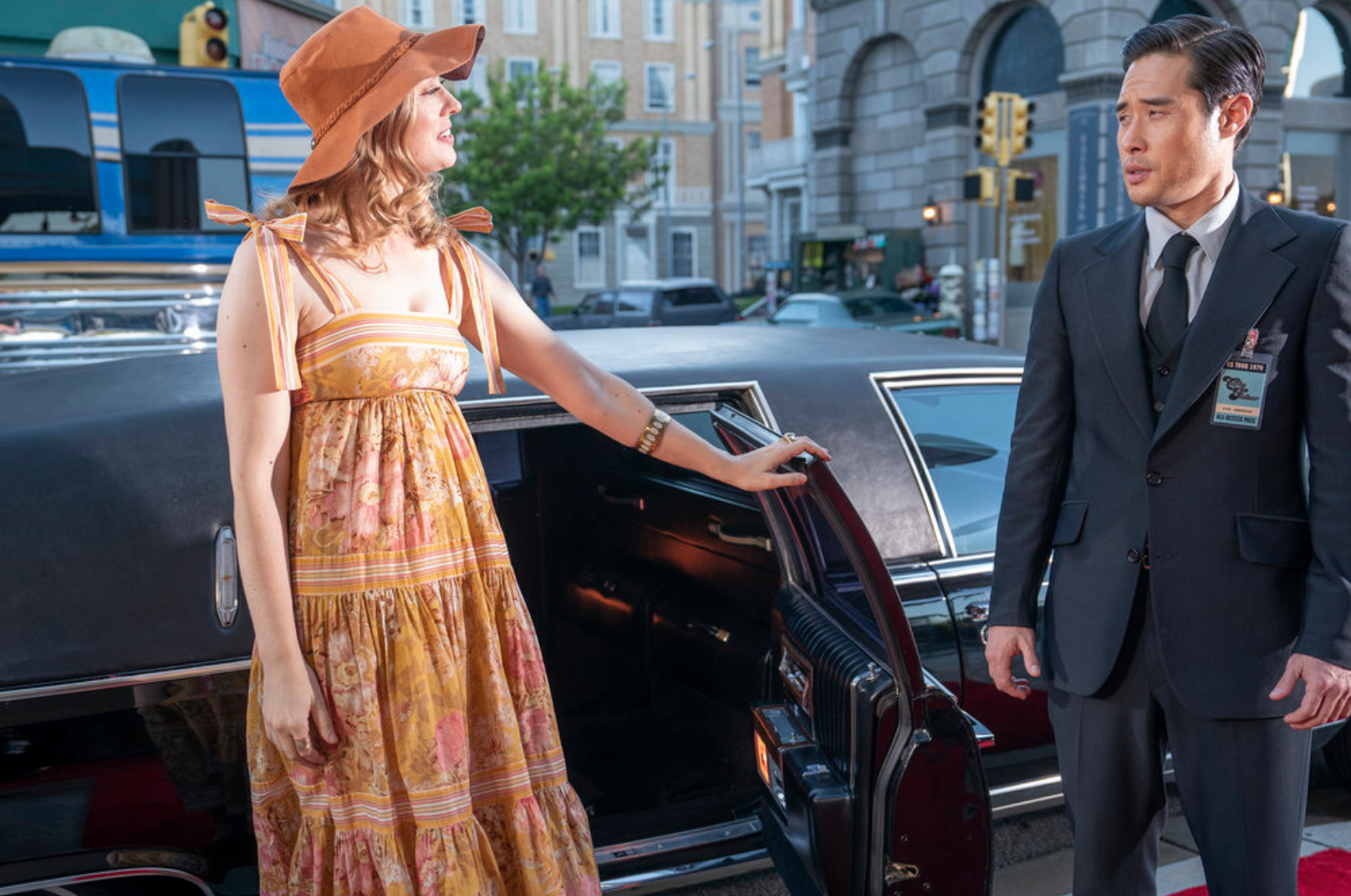 Carly stands outside a limo while Ben, as her bodyguard, watches