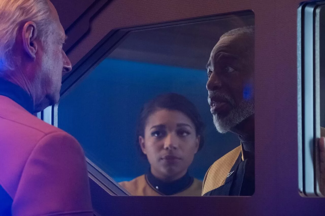 Geordi and Alandra look at Data/Lore through a door